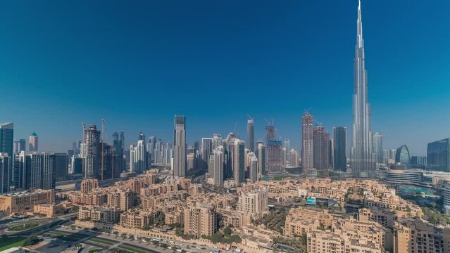 Dubai Downtown morning panoramic timelapse with sun reflected from tallest skyscraper and other towers view from the top during sunrise with long shadows moving fast, United Arab Emirates. Traditional