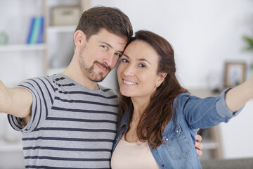 happy couple is using smartphone at home