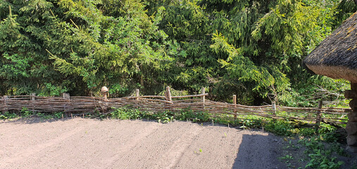 Spring garden at a traditional Slavic wooden thatched house on a sunny day.