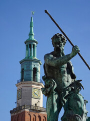 A fragment of the Neptune fountain and the town hall tower in the Old Market Square in Poznań on a...