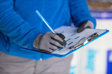 cropped view of gloved hand writing on clipboard © auremar