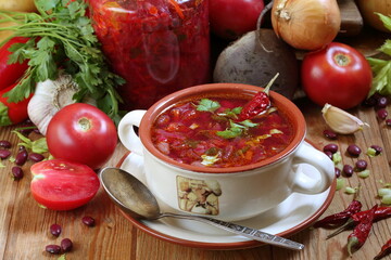 Borscht with sour cream, garlic and hot peppers on a wooden table	
