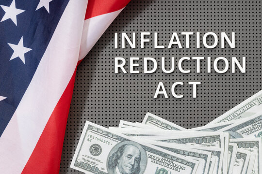 Inflation reduction Act law concept. Fat lay of text, american flag and dollar banknotes