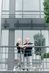 a woman and a man embrace near a glass building