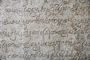 Inscriptions of ancient language carved on the stone walls at Hindu temple in Mahabalipuram, Tamilnadu, India. Ancient tamil inscriptions carved in the exterior temple walls in Mahabalipuram.