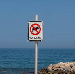 The inscription on the prohibition sign in Catalan "Gossos no" at the entrance to the beach. What does "No dogs" mean in translation.No pets sign, prohibition, forbidden circle, crossed out red circle