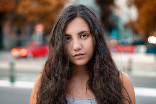Mujer joven de cabello largo casta&ntilde;o en la ciudad.