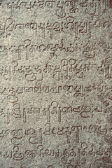 Inscriptions of ancient language carved on the stone walls at Hindu temple in Mahabalipuram,...