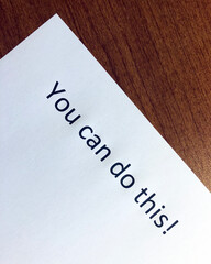 "You Can Do This" inspirational quote on paper sitting on a wood desk surface.