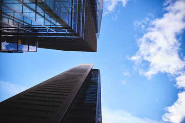 Vue vers le haut dans le quartier financier avec des vitres sur bâtiment d'architecture et ciel bleu