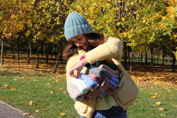 Hats crocheted knitted in the hands of a girlon the street. Product listing for sale. Urban style. Fashion. Autumn