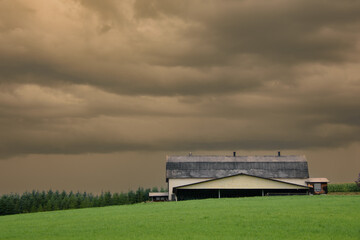 Obraz premium Canadian farm under stormy and threatening skies in the province of Quebec
