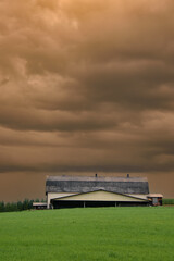 Fototapeta premium Canadian farm under stormy and threatening skies in the province of Quebec