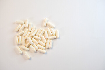 White pills on a white background.White capsules with lactic acid bacteria on a white background. 