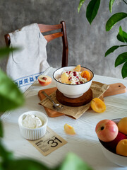 
Cottage cheese with fruits (peaches, apricots) in a bowl poured with jam on the table. Delicious...