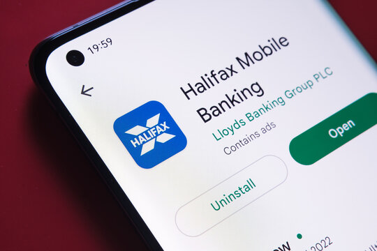 halifax banking app seen in Google Play Store on the smartphone screen placed on red background. Close up photo with selective focus. Stafford, United Kingdom, August 2, 2022.
