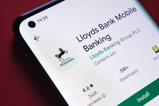 lloyds banking app seen in Google Play Store on the smartphone screen placed on red background. Close up photo with selective focus. Stafford, United Kingdom, August 2, 2022.