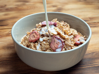 A cup with muesli and fresh berries on a wooden table. Healthy food, snack or breakfast.