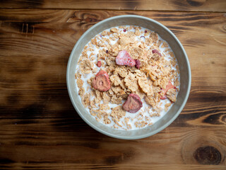 A cup with muesli and fresh berries on a wooden table. Healthy food, snack or breakfast.