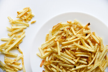 Delicious potato chips straws on a white saucer with sauce. Fast food with fried potato sauce straws.