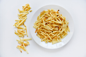 Delicious potato chips straws on a white saucer with sauce. Fast food with fried potato sauce straws.