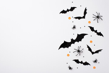 Halloween concept. Top view photo of bat silhouettes spiders and confetti on isolated white...