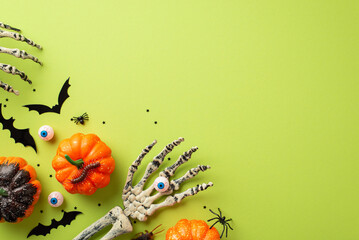 Halloween spooky decorations concept. Top view photo of skeleton hands holding eyeball pumpkins bat...