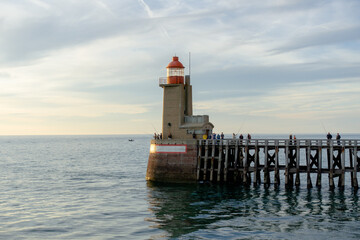 Fototapeta na wymiar A lighthouse in the sea illuminated by the evening sun