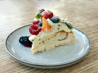 meringue cake with fruits and cream close up