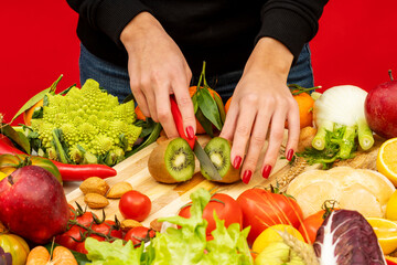 Horizontal shot of female hands cutting kiwi fruits