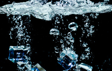 ice cubes in water with bubbles on black background