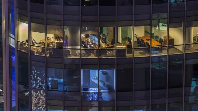 Big glowing windows in modern office buildings timelapse at night, in rows of windows light shines. Towers in financial center