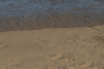 fragment of beach where the sea and the wet sand meet in Barcelona beach. Spain