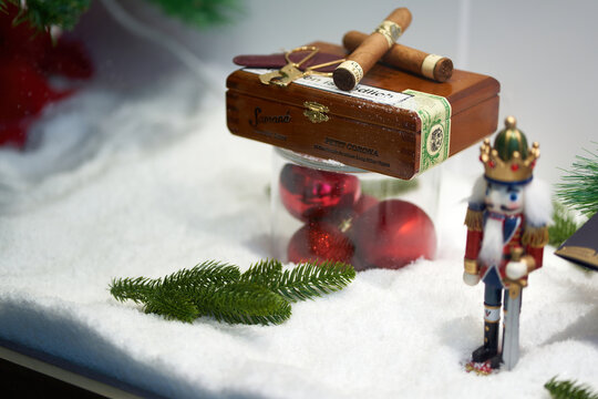 Wooden cigar box behind Christmas decorated shop window. Gift ideas for the annual feast. Nutcracker in bokeh.