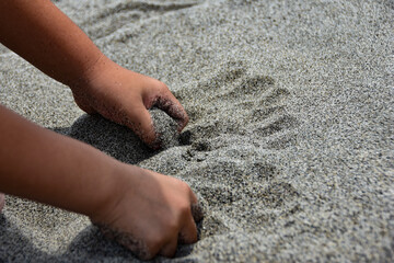砂浜で遊ぶ小さい子供の手