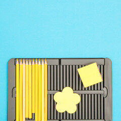 Trendy layout of yellow pencils and post it notes on bright blue background.  Flat lay. Creativity, workspace, back to School concept.