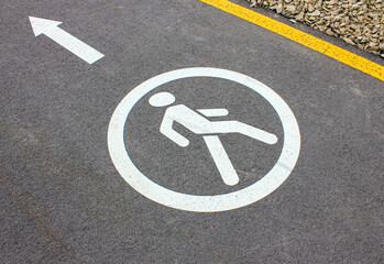 Circular white traffic sign. Asphalt road for pedastrians marked with special sign. White Pedestrian Symbol Painted over gray Asphalt with Arrow. Permission to move people. Signs drawn on the pavement