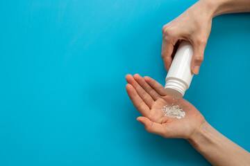 Woman applying baby talcum powder on hand. Skin care cosmetic