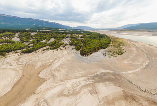 Aerial view of the Yesa reservoir and Aragón river with little water. To the left the Sierra de Leire and beech and pine forests. High resolution photo. Concept of climate change and drought.