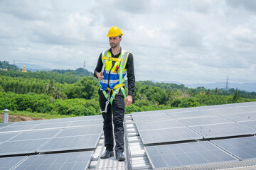 Engineer working and maintenance with solar batteries near solar panels at sunny day on roof structure of building factory,Alternative energy to conserve the world's energy.