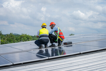 Fototapeta premium Engineers checking the operation of the system solar cell on an building in an residential area,Photovoltaic module idea for clean energy production.