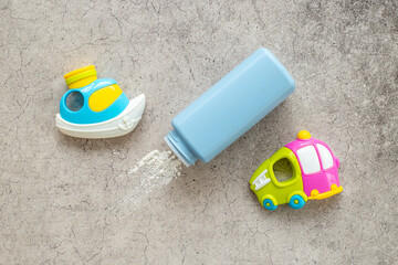 Talcum powder in container with kids toys. Baby care cosmetic