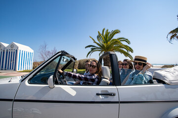 Five young women in a convertible car