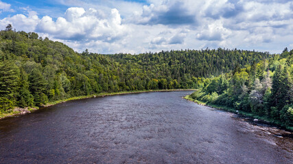 Drone View of Green Mountain Landscape, Summer Season in Canada, Water Stream flowing between Forest. 
