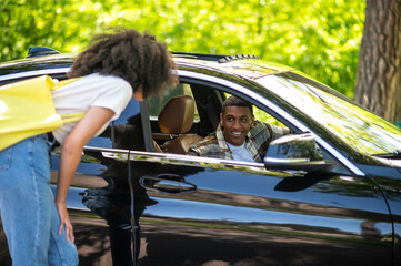 Hitchhiker talking to a car driver on the road