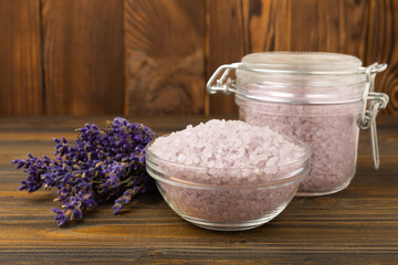 Obraz na płótnie Canvas Lavender sea salt on a brown wooden background. Himalayan sea salt and lavender flowers. Salt crystals from the Dead Sea.Spa concept. Space for copy. View from above