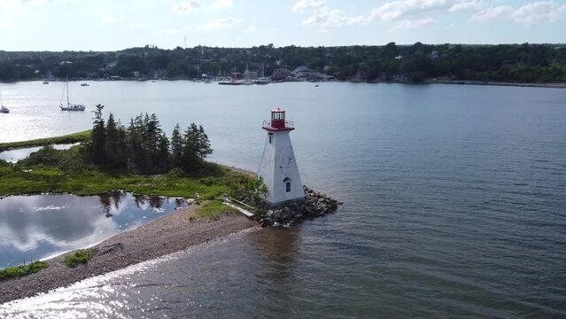 Circular aerial drone footage of the Kidston Island Lighthouse in Baddeck, Nova Scotia