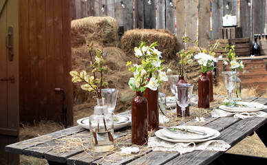 set table at a rural wedding. cutlery, plates and glasses