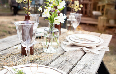 set table at a rural wedding. cutlery, plates and glasses