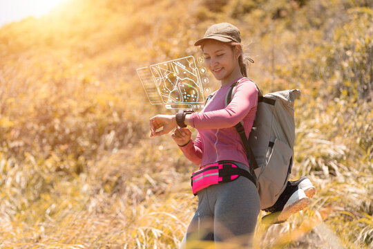 Concept Asian backpacker woman looking at smart map while trekking at the meadow in summer season. Solo travel woman traveling outdoor. - Powered by Adobe